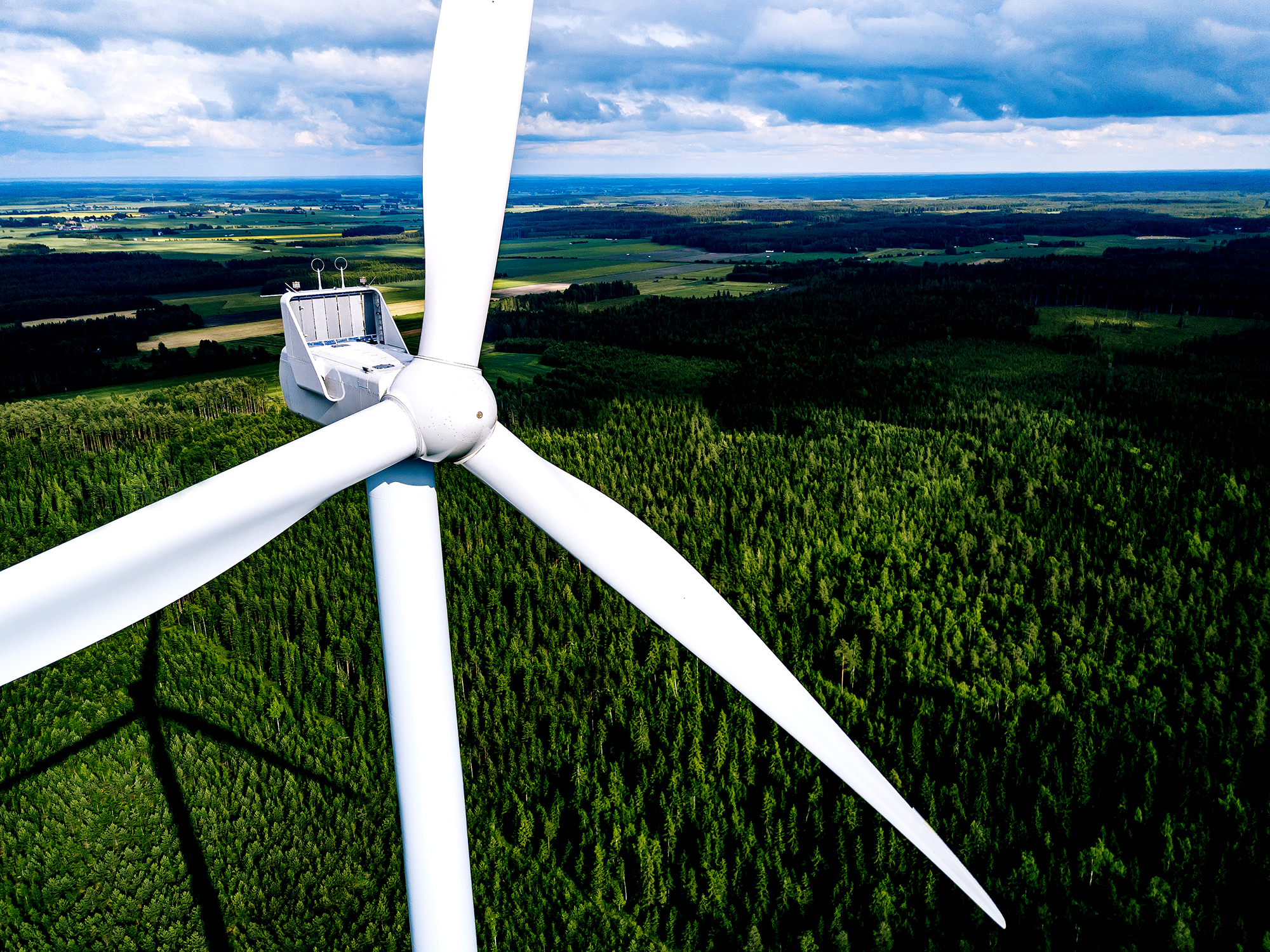 Aerial view of windmills in green summer forest in Finland close